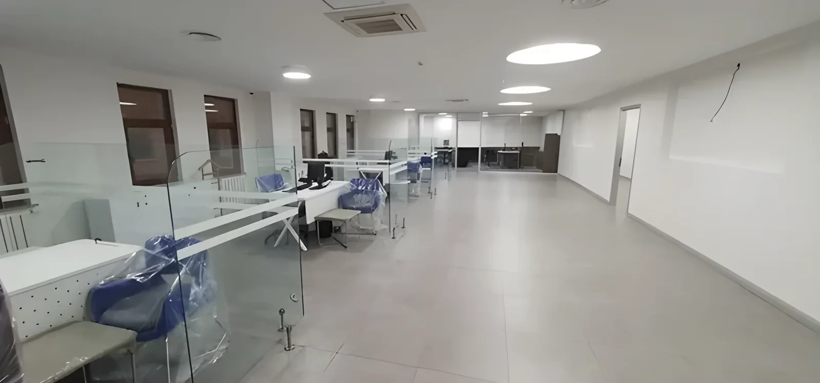 Cam paravanlı çalışma masaları ve geniş şube holü